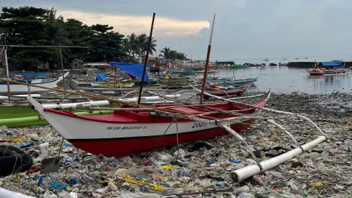 Plastikmüll im Wasser eines Fischerhafens
