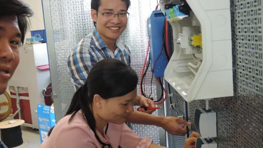 Vietnamesische Berufsschullehrer*innen üben das Verlegen von elektrischen Leitungen  in der Schulwerkstatt der HLFT