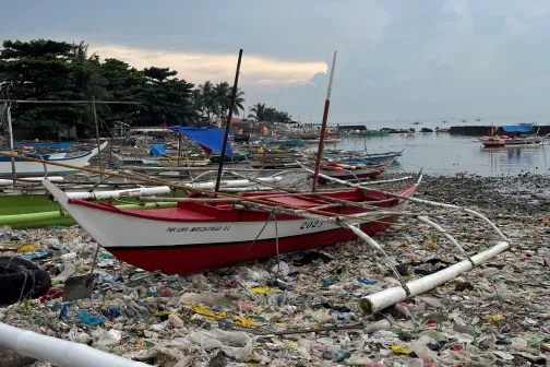 Plastikmüll im Wasser eines Fischerhafens