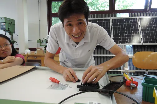 Ein vietnamesischer Berufsschullehrer montiert eine Solaranlage in der Werkstatt der HLFT