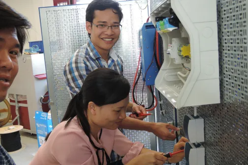 Vietnamesische Berufsschullehrer*innen üben das Verlegen von elektrischen Leitungen  in der Schulwerkstatt der HLFT